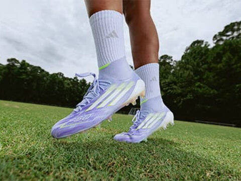 Đôi giày Adidas F50 màu tím nhạt đế FG trên chân cầu thủ giữa sân cỏ tự nhiên