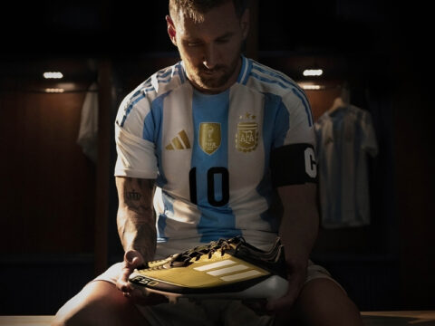 Lionel Messi mặc áo Argentina số 10 cầm đôi giày Adidas F50 màu vàng đen trong phòng thay đồ